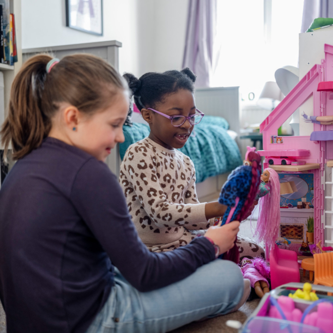 Kids in their room playing with a doll house