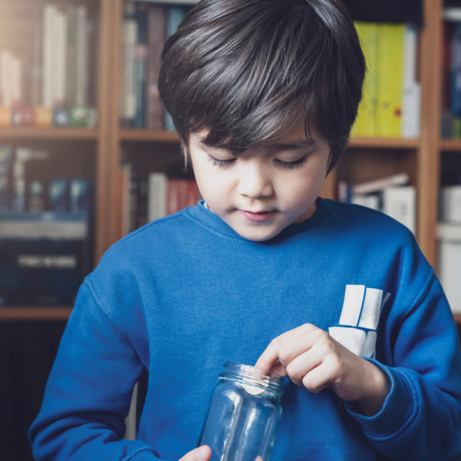 Young Kid Holding Money Coins In Clear Jar
